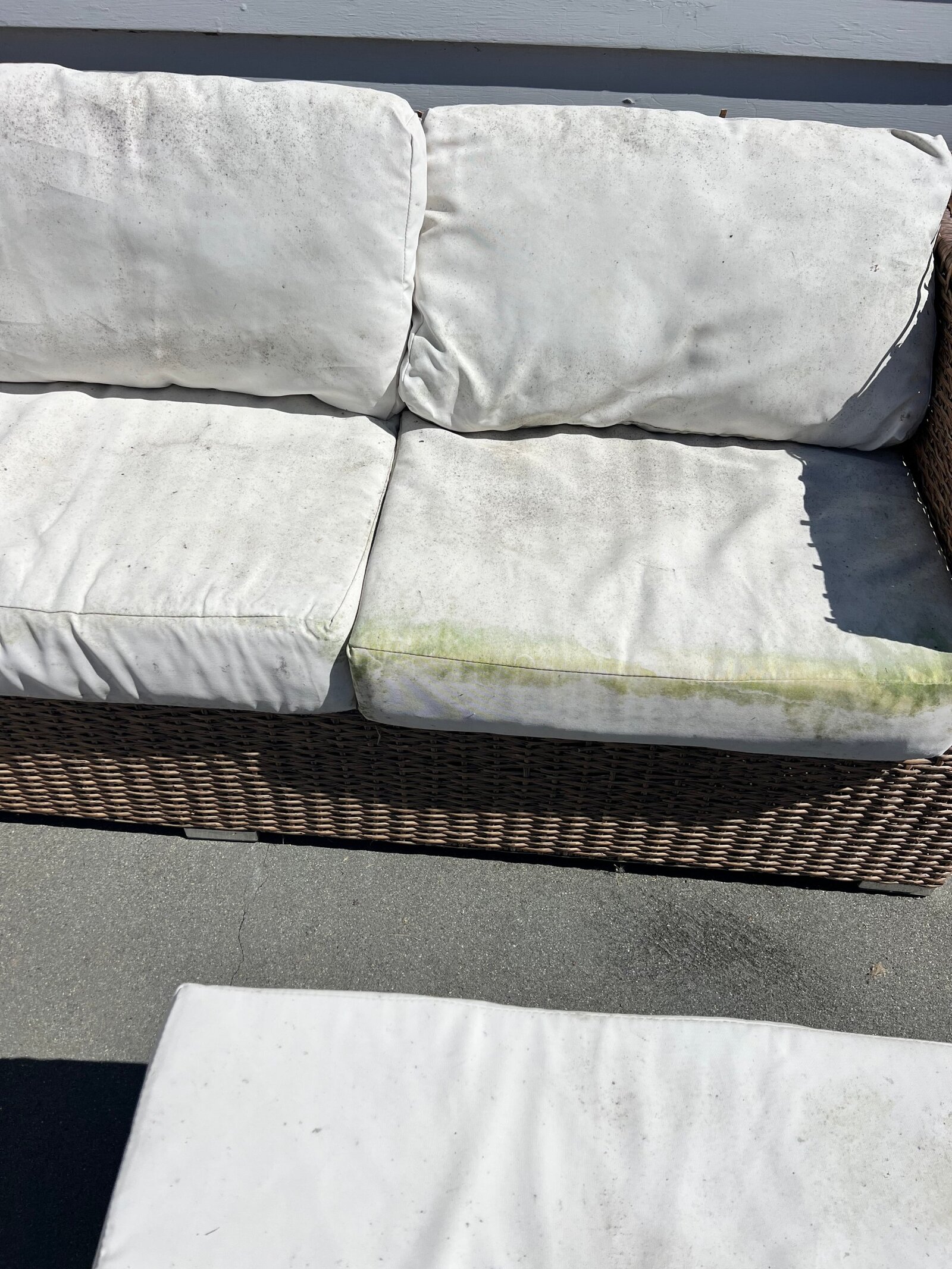 Before: white outdoor cushions with grime and a green mildew stain along the seat edge